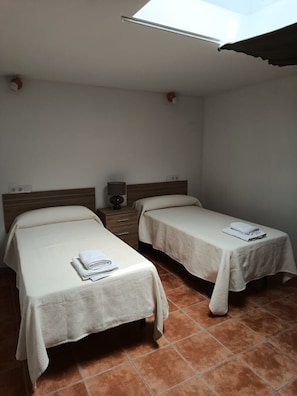 A room with two single beds, a bedside table with a lamp, and a small speaker. - Atalaya 4001 Ground-Floor Apartment (Arnuero)