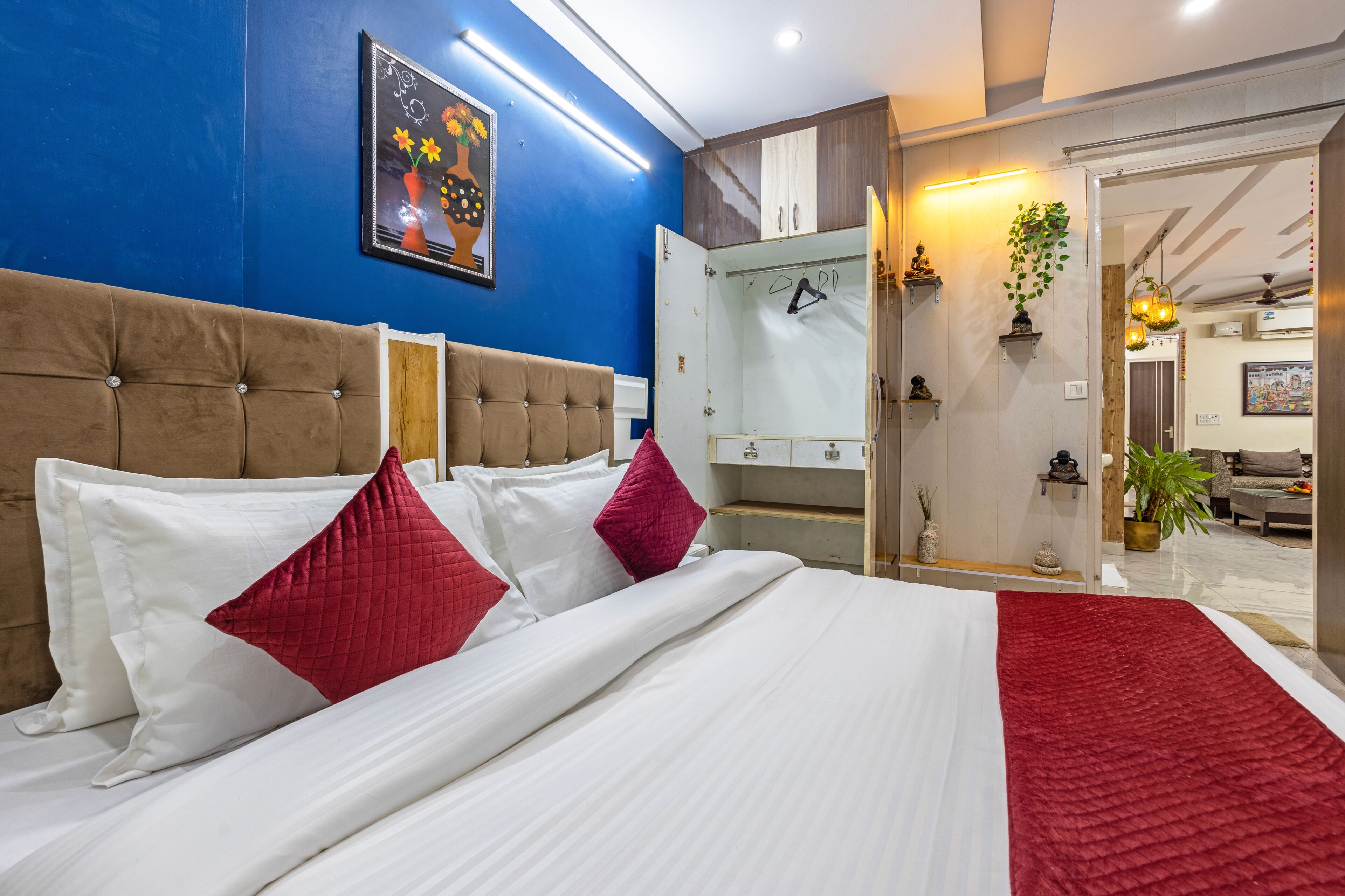 Une chambre d’hôtel comprenant un lit, une armoire, un miroir et une porte donnant sur une autre pièce.