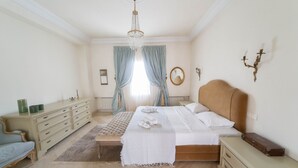 A bedroom with a bed, a dresser, a nightstand, a mirror, and a chandelier. - Villa d Exception Gammarth Piscine Priv e (La Marsa)