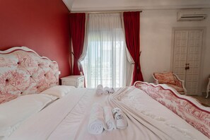 A hotel room with a large bed, a bedside table, a chair, and a wardrobe. - Villa d Exception Gammarth Piscine Priv e (La Marsa)