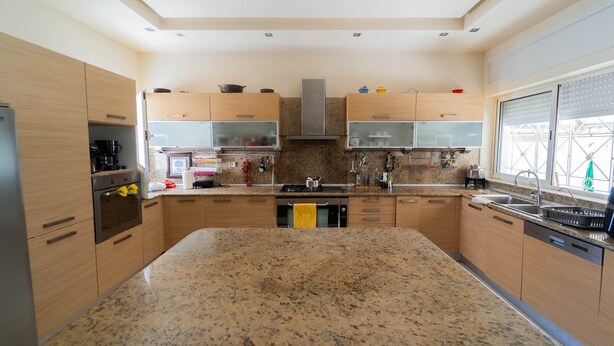 A modern kitchen with granite countertops, wooden cabinets, and stainless steel appliances. - Villa d Exception Gammarth Piscine Priv e (La Marsa)