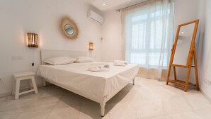 Ein Schlafzimmer mit einem Bett, Nachttischlampen, einem Spiegel und einer Staffelei aus Holz.