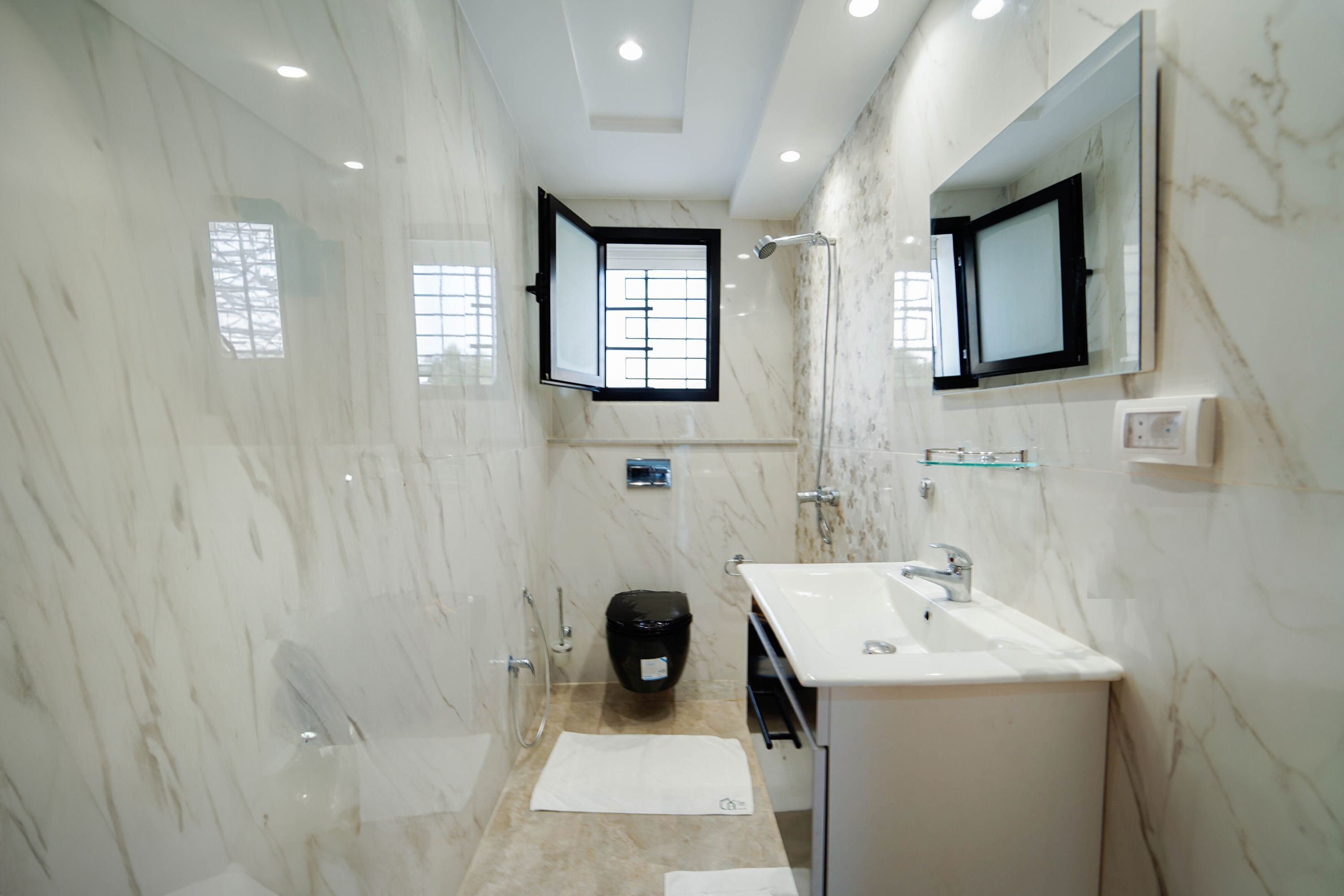 Ein modernes Badezimmer mit Dusche, Waschbecken und Spiegel.