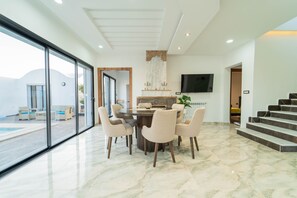 A modern dining area with a marble floor, a round table, and six chairs. - 3-bedroom Villa With Private Pool Studio (Hammamet)