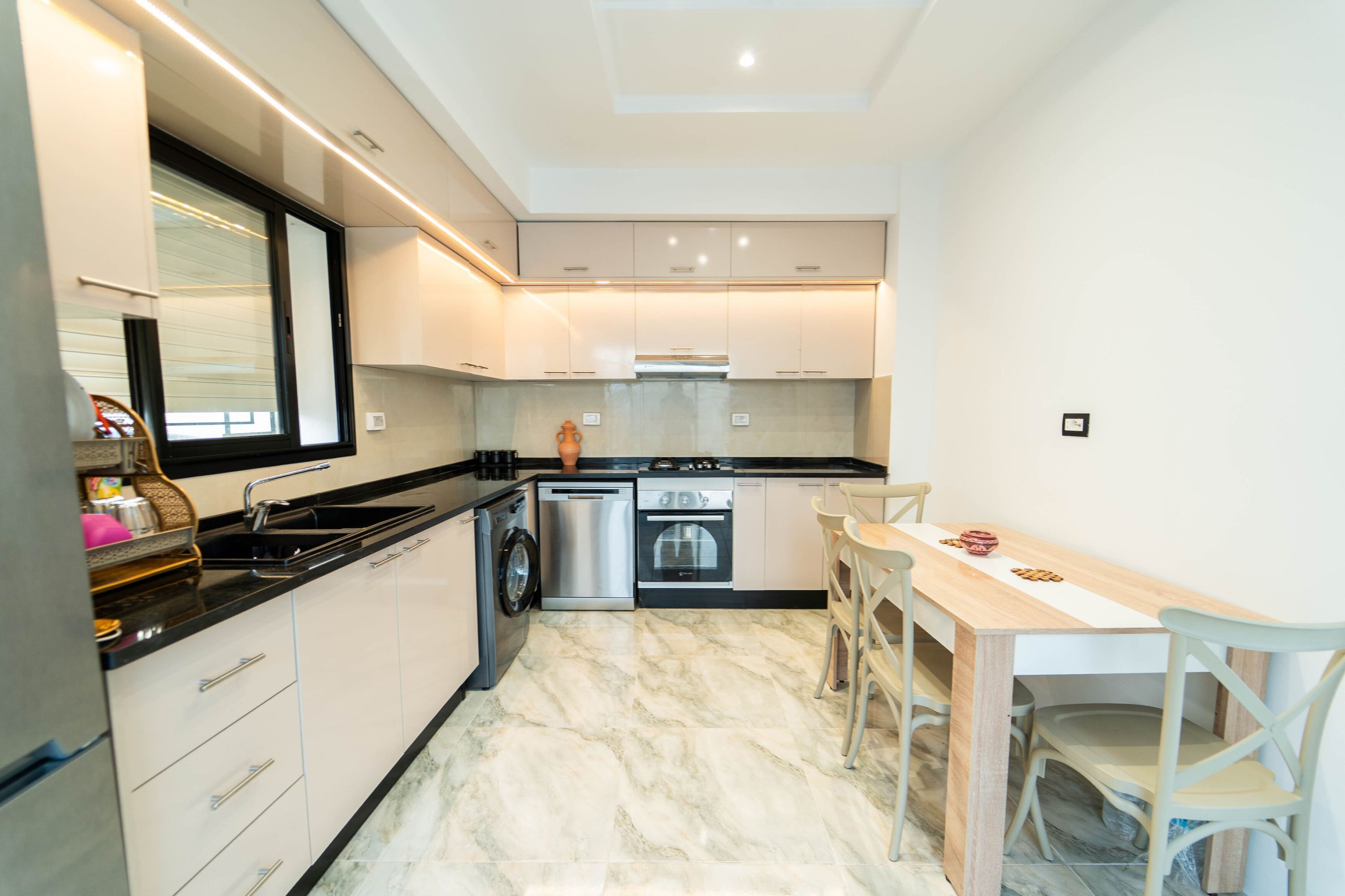 Una cocina moderna con horno empotrado, lavavajillas y un lavabo.