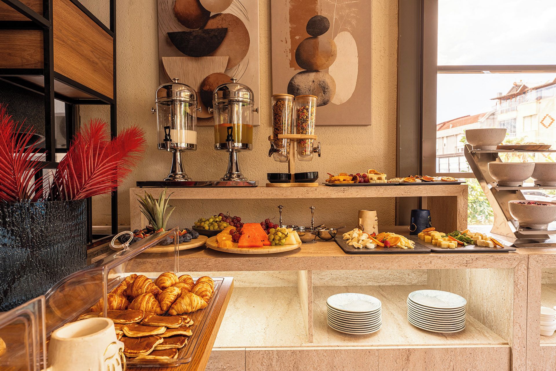 A buffet setup with various food items, including pastries, fruits, and cheeses.