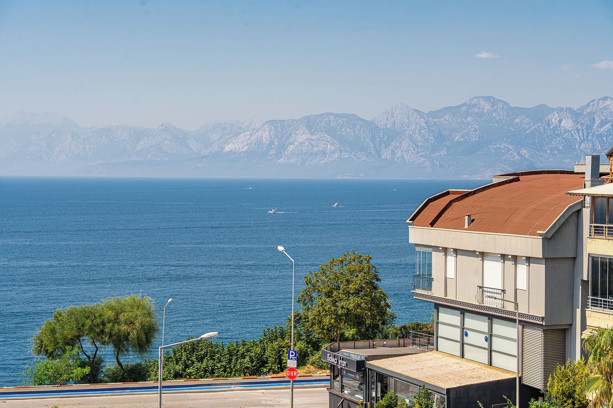 Un edificio costero con vistas al mar y a las montañas.