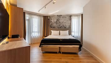 Une chambre d’hôtel moderne avec un grand lit, un bureau en bois et une fresque murale.