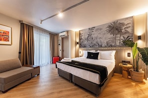 Une chambre d’hôtel comprenant un lit, un canapé, une grande fenêtre avec des rideaux, un climatiseur fixé au mur, une œuvre d’art murale et une plante en pot.