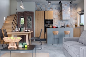 A modern kitchen with a built-in microwave, wooden cabinets, and a patterned backsplash. - Villa Iron Lady Labin Private Pool & Sea View (Labin)