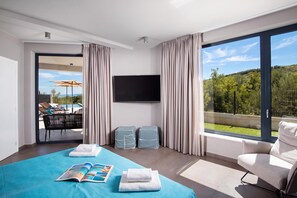A modern hotel room with a large bed, a flat-screen TV, and a balcony with a pool view. - Villa Awesome Lodge (Rasa)