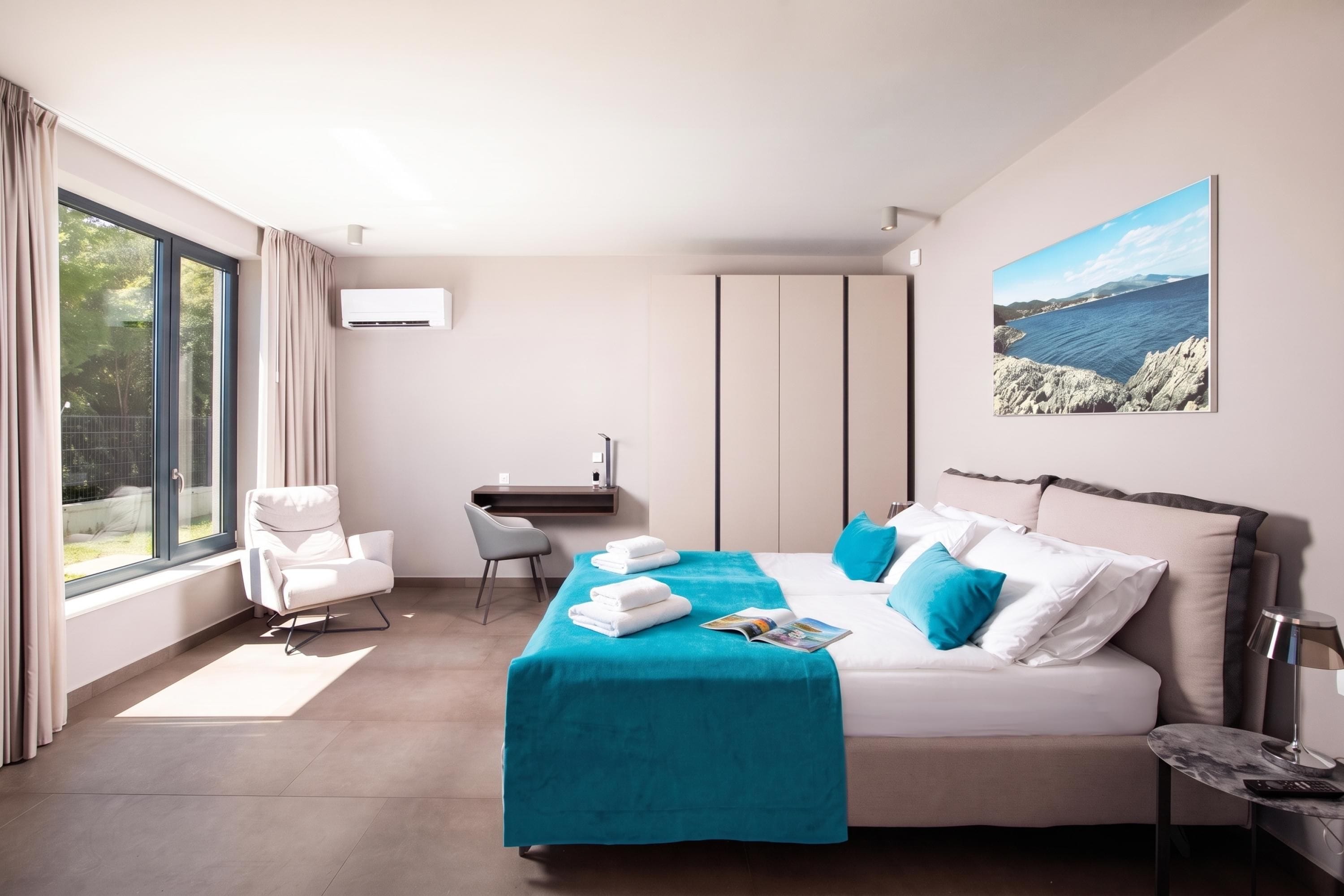 A modern hotel room with a large bed, a desk, and a chair.