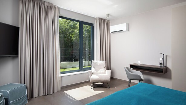 A hotel room with a bed, a desk, a chair, a TV, and a window with curtains. - Villa Awesome Lodge (Rasa)