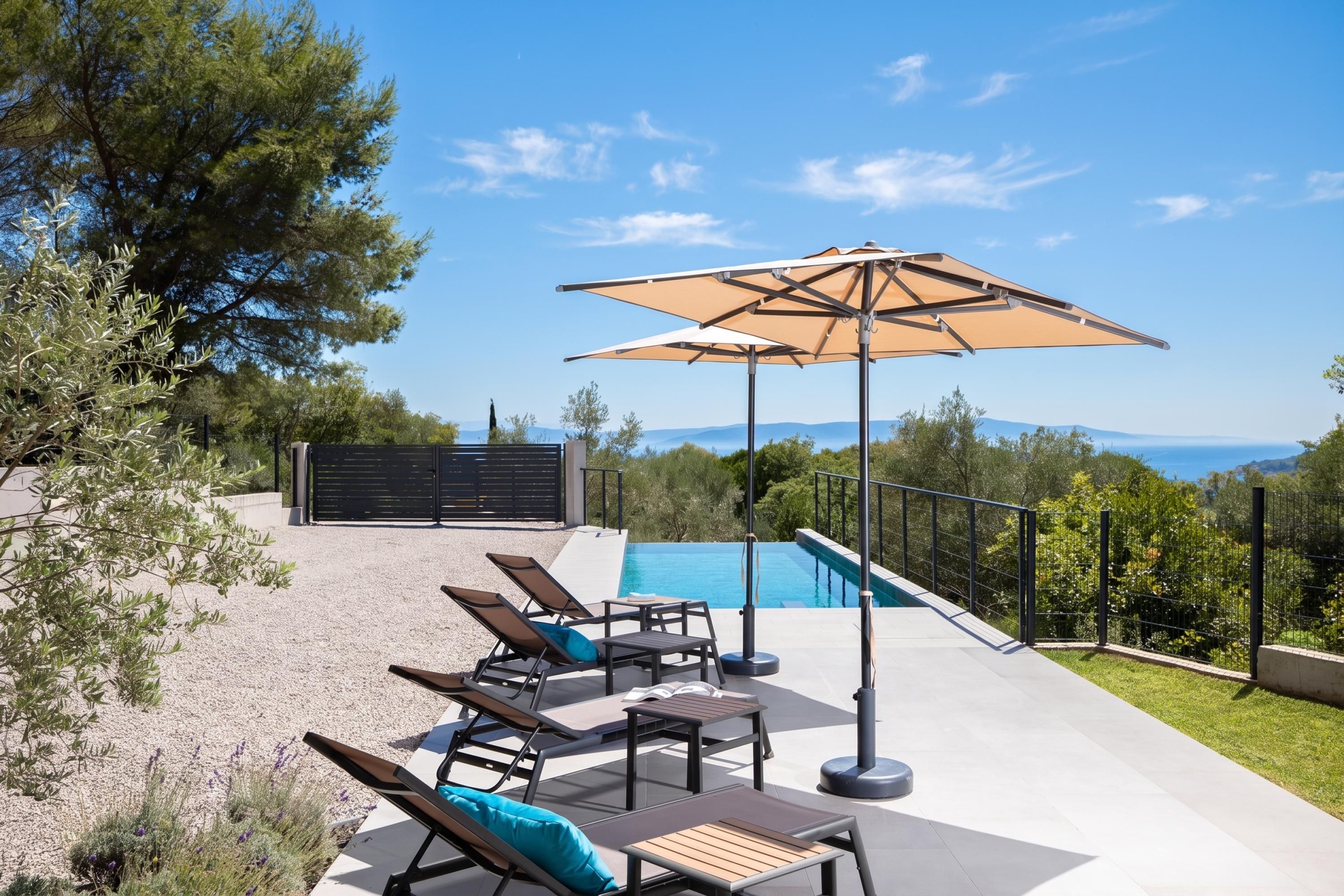 Uma área na piscina com espreguiçadeiras, uma mesa e um guarda-sol.