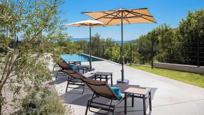 An outdoor patio with a pool, lounge chairs, and umbrellas. - Villa Awesome Lodge (Rasa)