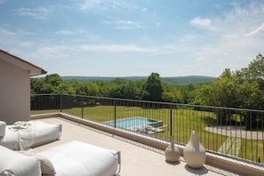 A balcony with a pool, white outdoor furniture, and a view of a green landscape. - Villa Baracchi 4 BDR Pool Villa With Sauna in Krsan (Krsan)