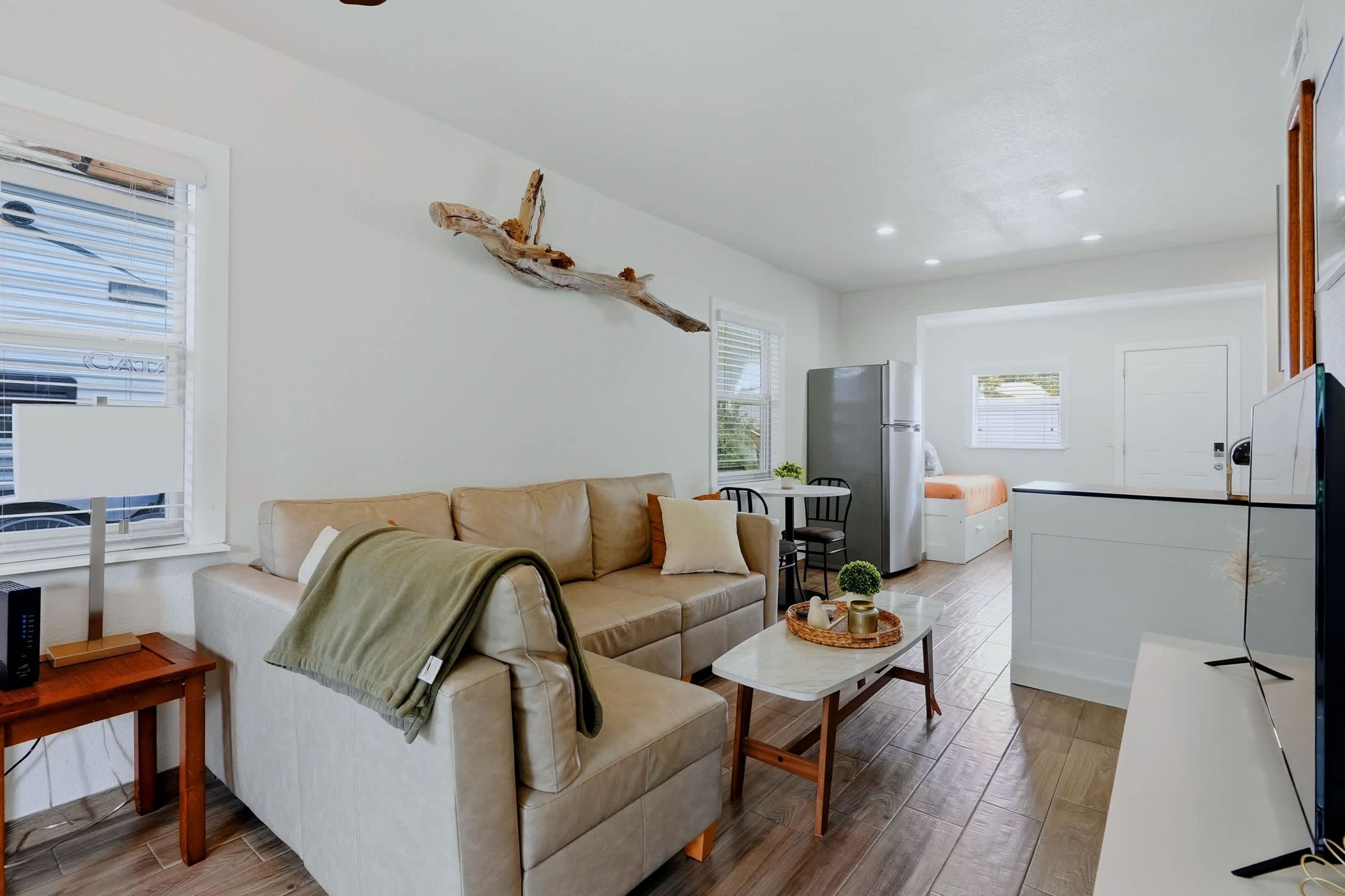 Uma sala de estar moderna com sofá, mesa de centro e área de jantar com mesa e cadeiras.