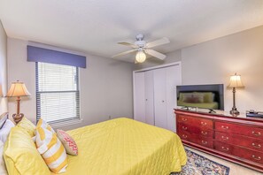 A bedroom with a bed, a television, a dresser, and a ceiling fan. - Phoenix II 2031 by Liquid Life (Orange Beach)