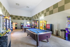 Een kamer met pooltafels en spelautomaten.