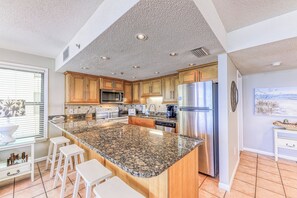 A modern kitchen with granite countertops, stainless steel appliances, and wooden cabinets. - Phoenix II 2031 by Liquid Life (Orange Beach)