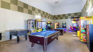 Una sala de recreación con mesas de billar, fútbol de mesa y diversos juegos de arcade.