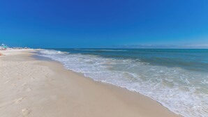 Una playa con cielos despejados y olas tranquilas.