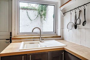 A kitchen with a window, a sink, and a utensil rack. - Quaint Cottage in Charming Evesham (Evesham)