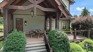 A wooden structure with a porch, a dining table with chairs, and a sign indicating 'The Millhouse Lodge'. - Millhouse Lodge | Large Group Retreat | Sleeps 30 (Murphy)