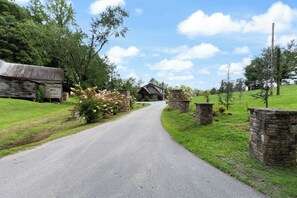A rural road leading to a stone building with a wooden barn on the left. - Millhouse Lodge | Large Group Retreat | Sleeps 30 (Murphy)