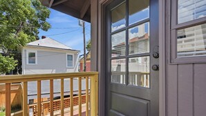 A residential property with a front door, a wooden deck, and a view of neighboring houses. - The Magnolia Suite at One 01 (Savannah)