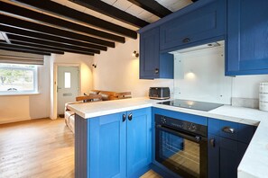 A modern kitchen with blue cabinets, a built-in oven, and a coffee maker. - Host Stay Cuit s View (Middlesbrough)