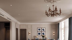 Un salón amplio con un conjunto de sofás, sillones, una mesa de centro y una araña.