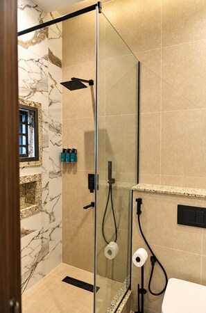 A modern bathroom with a glass-enclosed shower, marble wall tiles, and a granite countertop. - Sansa Residence (Abuja)