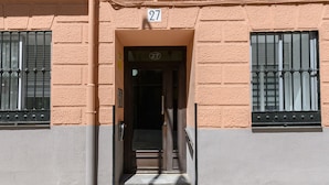 A building entrance with a number 27 sign, a door, and steps leading up to it. - (MGU272D) 2-bedroom apartment in Chamberí (Madrid)
