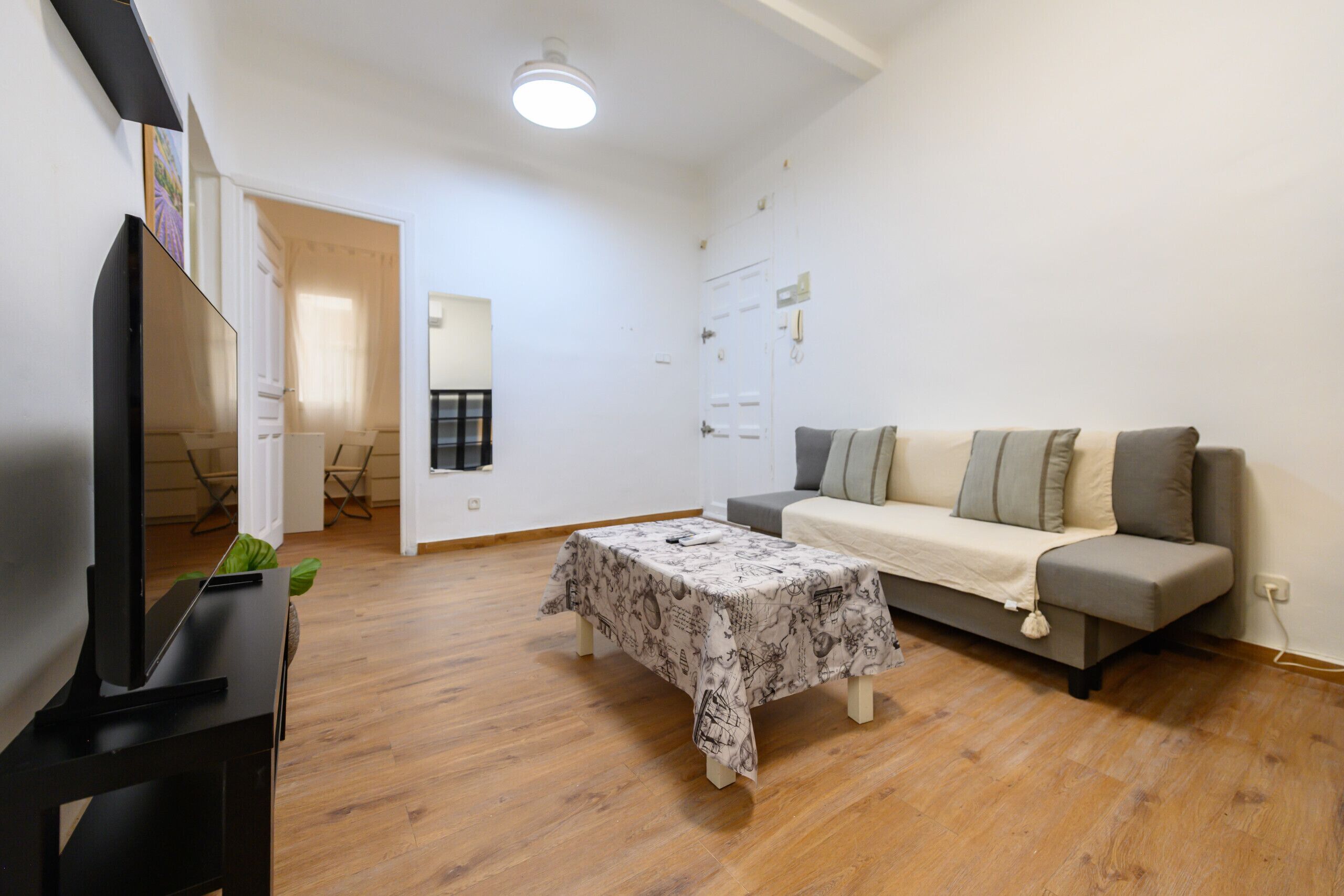 A living room with a sofa, a coffee table, and a television.