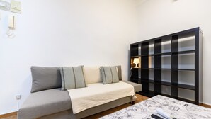 A modern living room with a sofa, a table with a map, and a black shelving unit. - (MGU272D) 2-bedroom apartment in Chamberí (Madrid)
