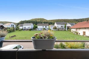 Un quartiere residenziale con case, un giardino erboso e una collina sullo sfondo.