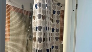 Een douche, een haardroger, een bidet, handdoeken