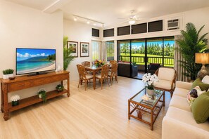 A living room with a television, dining table, chairs, and a sofa. - Kapalua Ridge | 3 Ocean View Villas, Sleeps 16 | Car Incl. w/ 6+ Nights | ML-4256 by KBM (Lahaina)