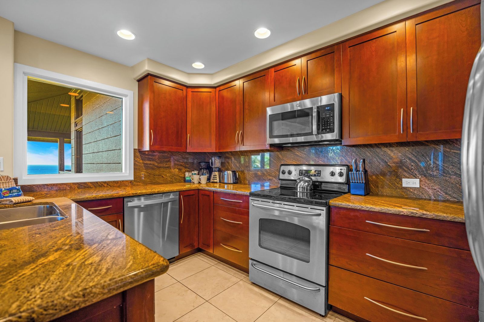 A kitchen with wooden cabinets, a stainless steel microwave, a stove, and a dishwasher.