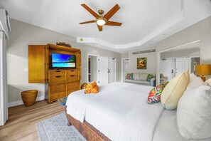 A bedroom with a large bed, a ceiling fan, a TV on a wooden cabinet, and a painting on the wall. - Kapalua Ridge | 3 Ocean View Villas, Sleeps 16 | Car Incl. w/ 6+ Nights | ML-4256 by KBM (Lahaina)