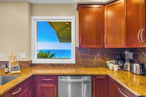 A kitchen with a view of the ocean, a coffee maker, and a blender. - Kapalua Ridge | 3 Ocean View Villas, Sleeps 16 | Car Incl. w/ 6+ Nights | ML-4256 by KBM (Lahaina)