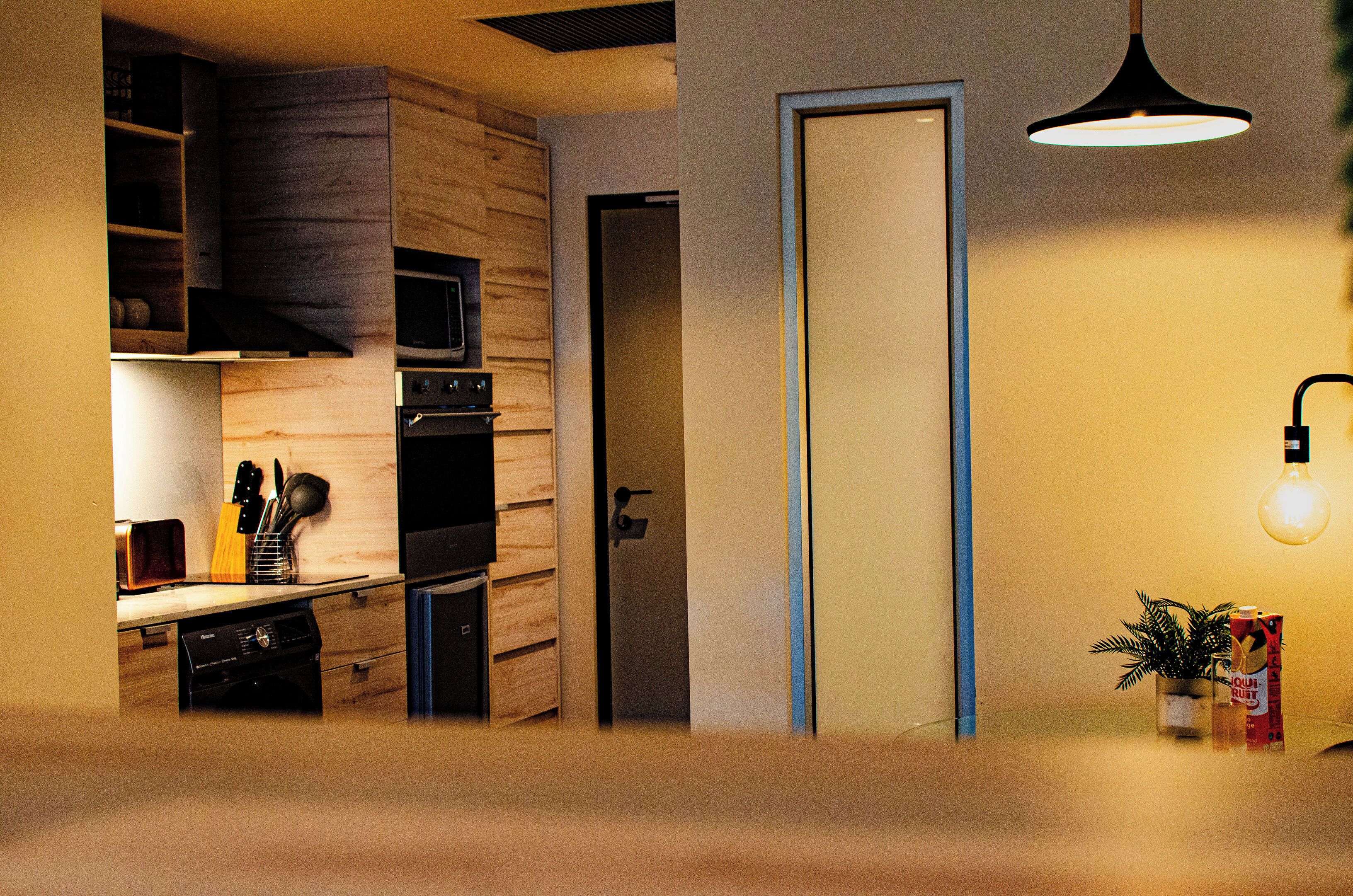 A modern kitchen with a microwave, oven, and wooden cabinets.