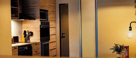 A modern kitchen with a microwave, oven, and wooden cabinets.