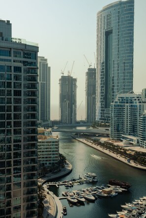 A marina with boats docked, surrounded by high-rise buildings and construction cranes. - Partial marina view prime location (Dubai)