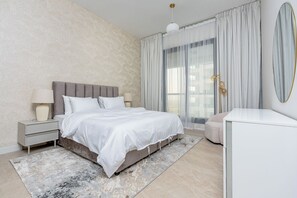 A modern bedroom with a large bed, bedside tables, a nightstand, a dresser, and a large window with curtains. - Partial marina view prime location (Dubai)