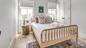 Ein Schlafzimmer mit einem hölzernen Bett, einem Deckenventilator und einer gemusterten Decke.