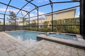 Ein Außenpoolbereich mit Glasveranda, zwei Whirlpools und Blick auf ein Wohngebäude.