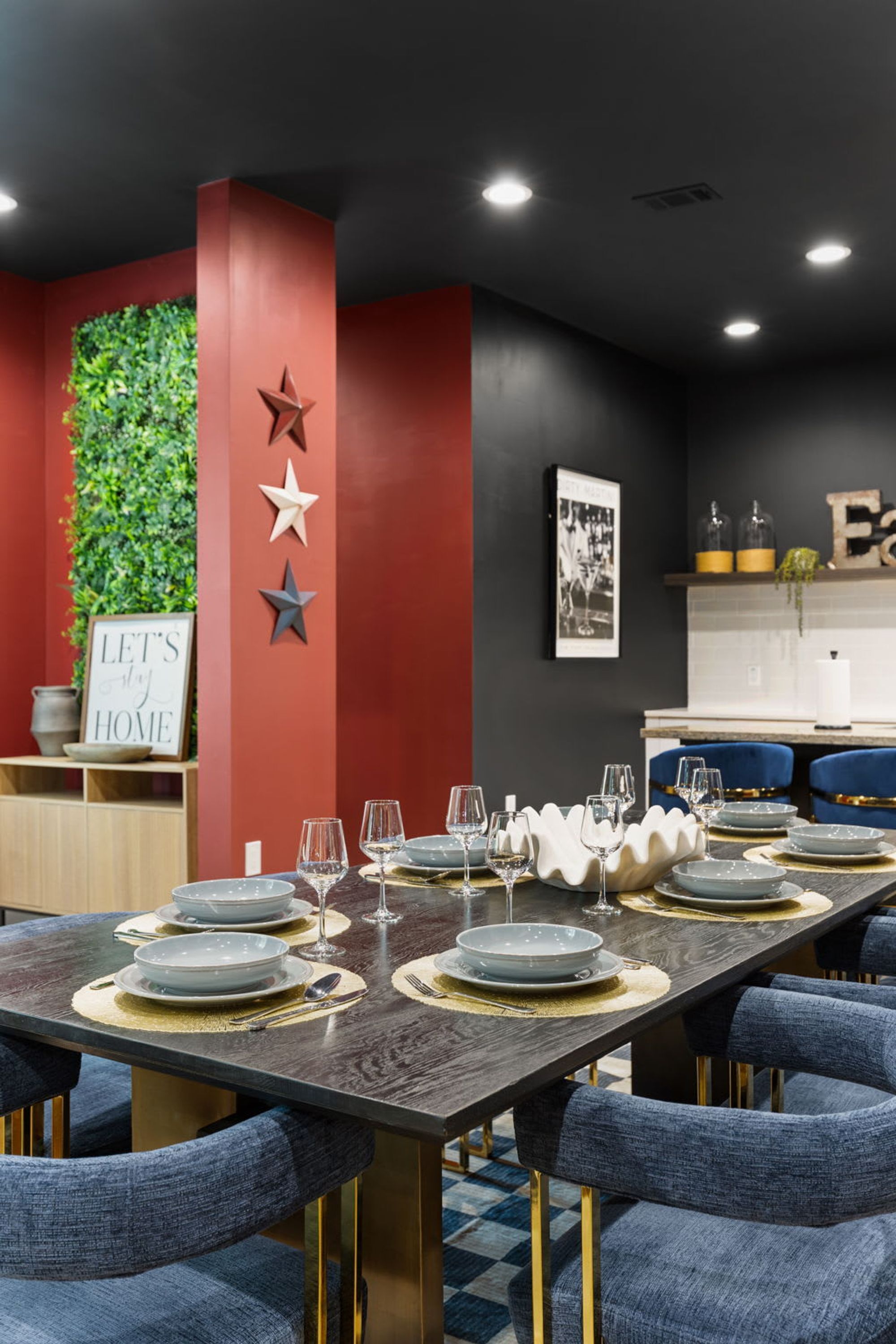 Comedor con una mesa larga dispuesta para seis personas, rodeada de sillas tapizadas en azul con patas doradas.