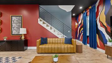 A modern living room with a sofa, a coffee table, and a staircase.